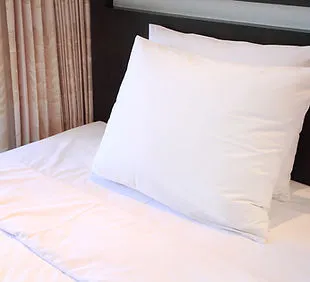 Crisp hotel bed with stacked pillows